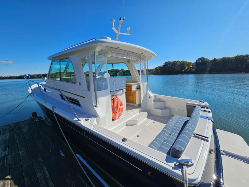 Slide: The Image of 2008 Back Cove 33 boat docked on a sunny day, showcasing sleek design and spacious deck. - 37