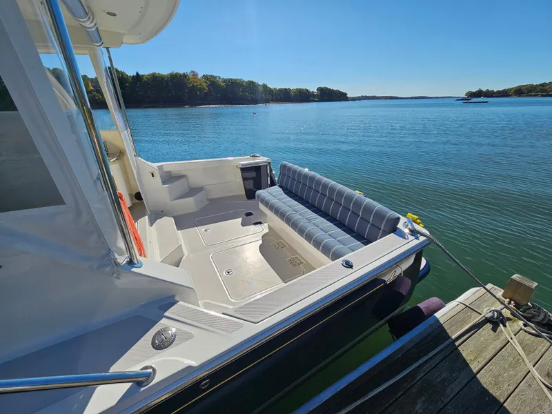 Slide: The Image of 2008 Back Cove 33 boat docked on a serene lake with clear blue skies. - 38