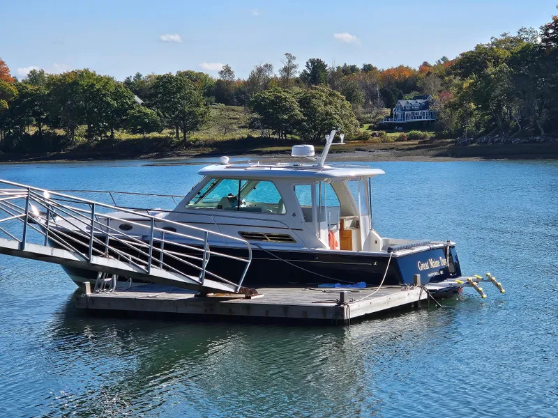 Slide: The Image of 2008 Back Cove 33 boat docked on calm water with scenic background. - 40