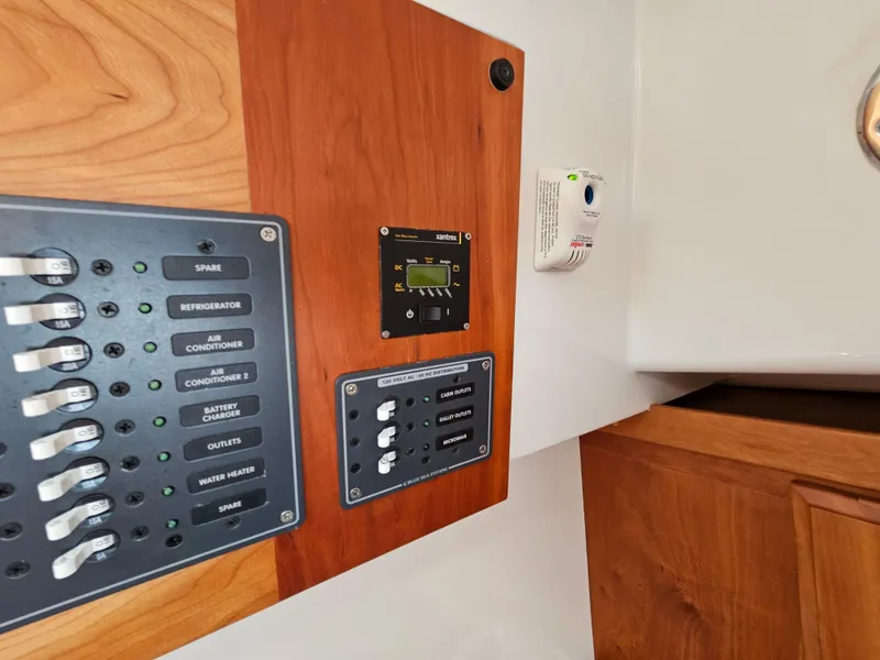 Slide: The Image of Electrical panel on a 2008 Back Cove 33 boat with switches and controls. - 45