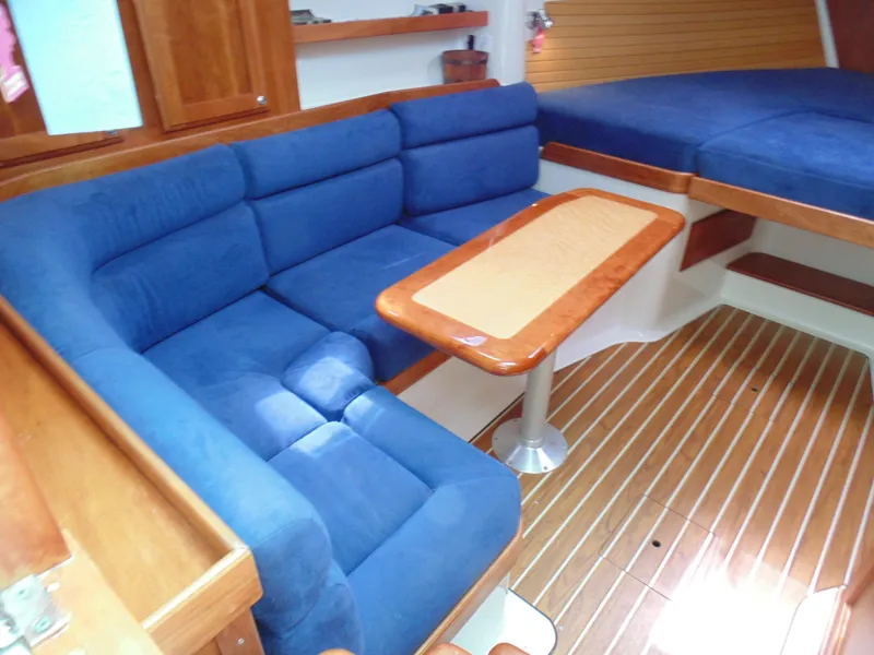 Slide: The Image of 2008 Back Cove 33 interior with blue seating and wooden table. - 6