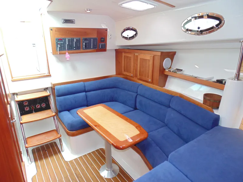 Slide: The Image of Interior of 2008 Back Cove 33 yacht with blue seating and wooden table. - 8