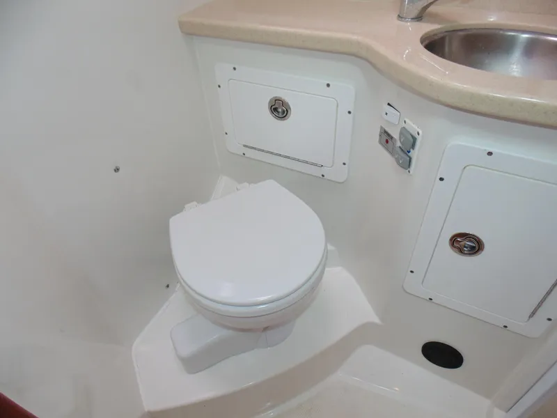 Slide: The Image of 2008 Back Cove 33 boat bathroom with toilet, sink, and storage compartments. - 9