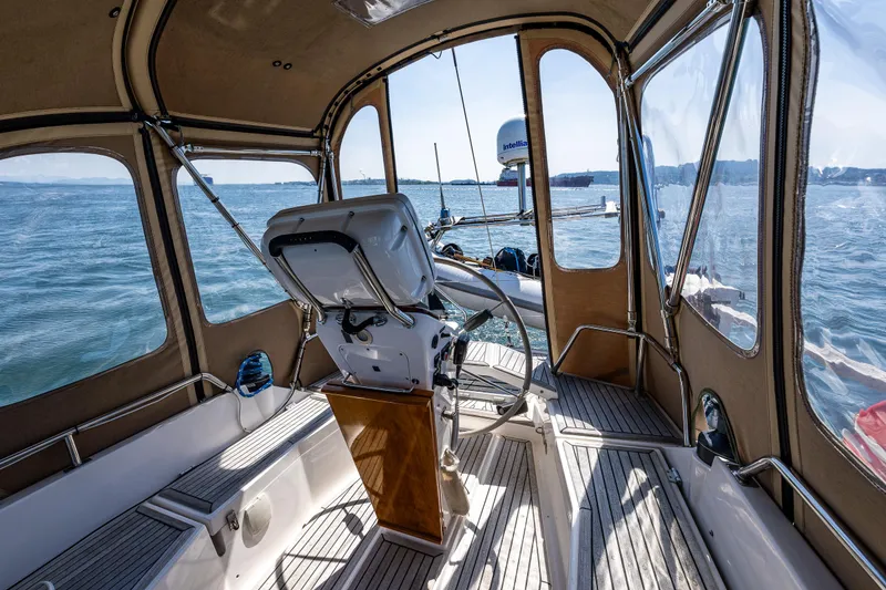 Slide: The Image of Nauticat 35 Pilot House 2000 interior with helm, overlooking serene waters. - 13