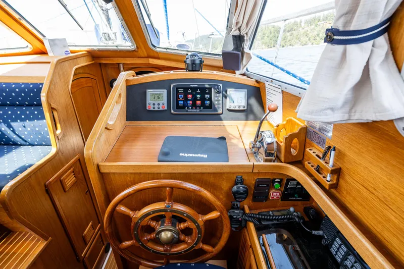 Slide: The Image of Pilot house interior of 2000 Nauticat 35, featuring wooden helm and navigation instruments. - 18