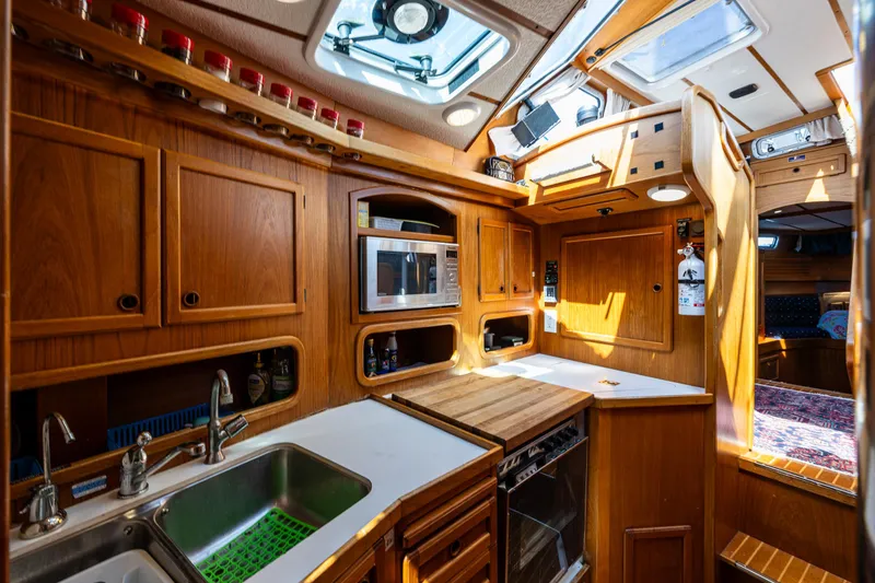 Slide: The Image of Nauticat 35 Pilot House 2000 interior with wooden cabinetry and modern kitchen amenities. - 25