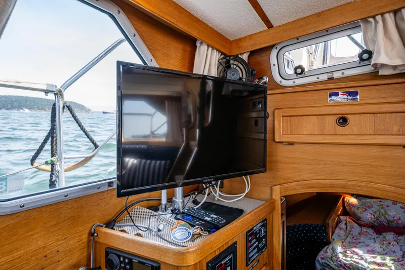 Slide: The Image of Nauticat 35 Pilot House 2000 interior with TV, wooden cabinetry, and ocean view. - 26