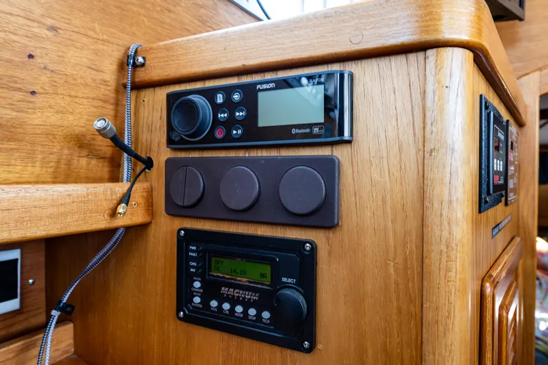 Slide: The Image of Wooden control panel in a 2000 Nauticat 35 Pilot House with radio and navigation equipment. - 27