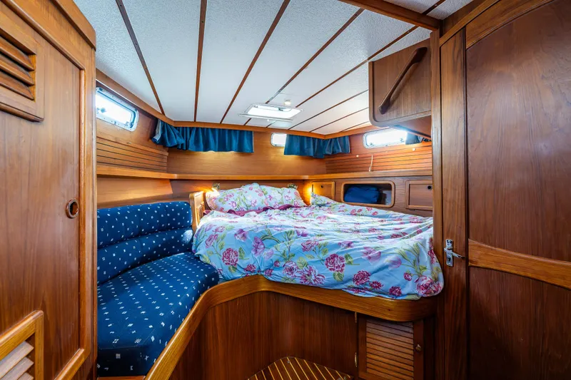 Slide: The Image of Cozy cabin interior of 2000 Nauticat 35 Pilot House with floral bedding and wood paneling. - 28
