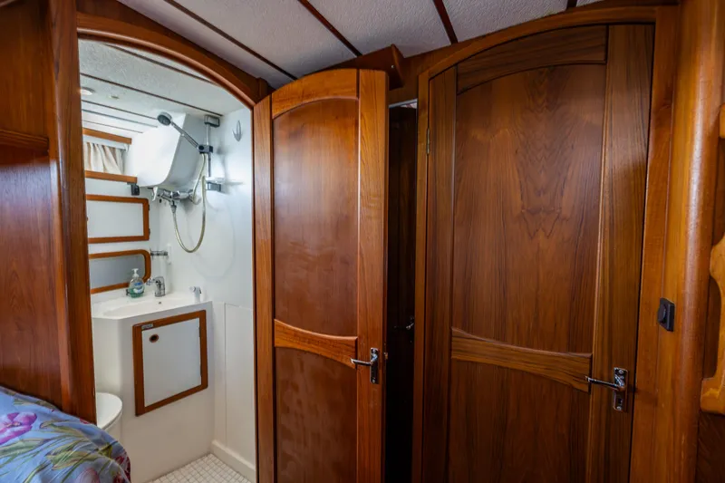 Slide: The Image of Interior of 2000 Nauticat 35 Pilot House, featuring wooden doors and compact bathroom. - 30