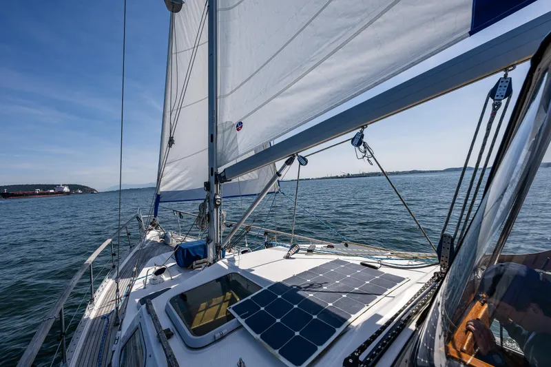 Slide: The Image of Sailing on a 2000 Nauticat 35 Pilot House with solar panels, under clear blue skies. - 6