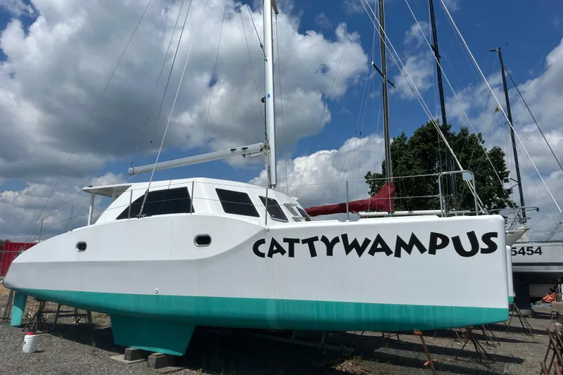 The Image of Kelsall 38ma catamaran named "Cattywampus" on land, under a partly cloudy sky. - 0