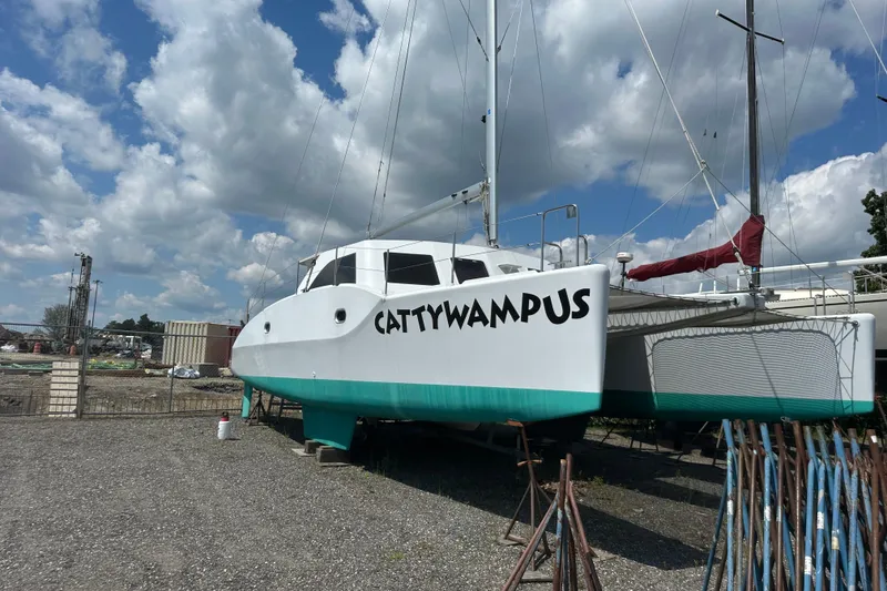 Slide: The Image of Kelsall 38ma catamaran named "Cattywampus" on land, under a partly cloudy sky. - 12