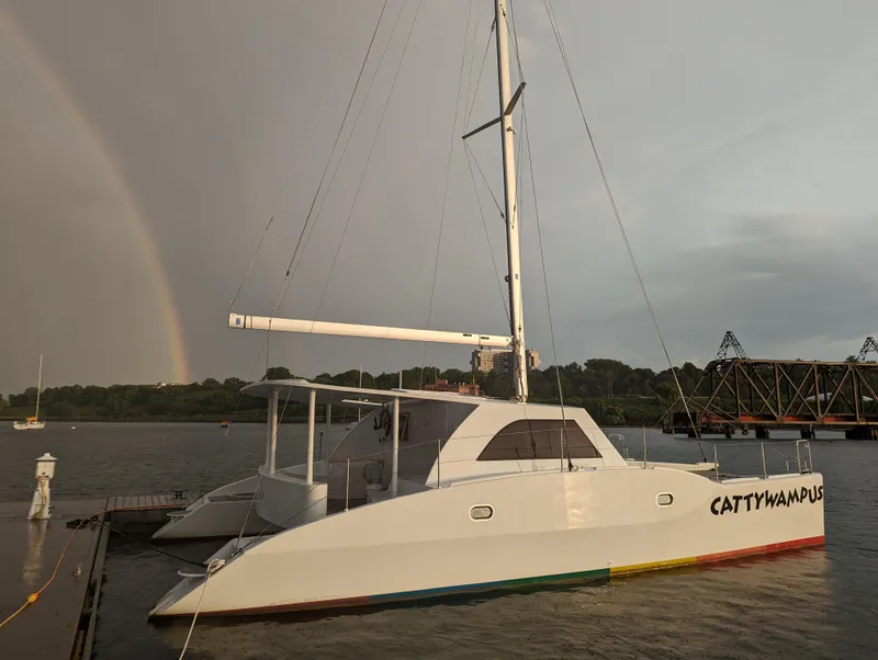 Slide: The Image of Kelsall 38ma catamaran docked, rainbow in background, 2019 model. - 2