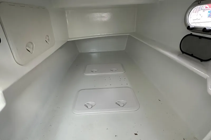 Slide: The Image of Interior of a 2019 Kelsall 38ma boat, featuring storage compartments and a porthole. - 42