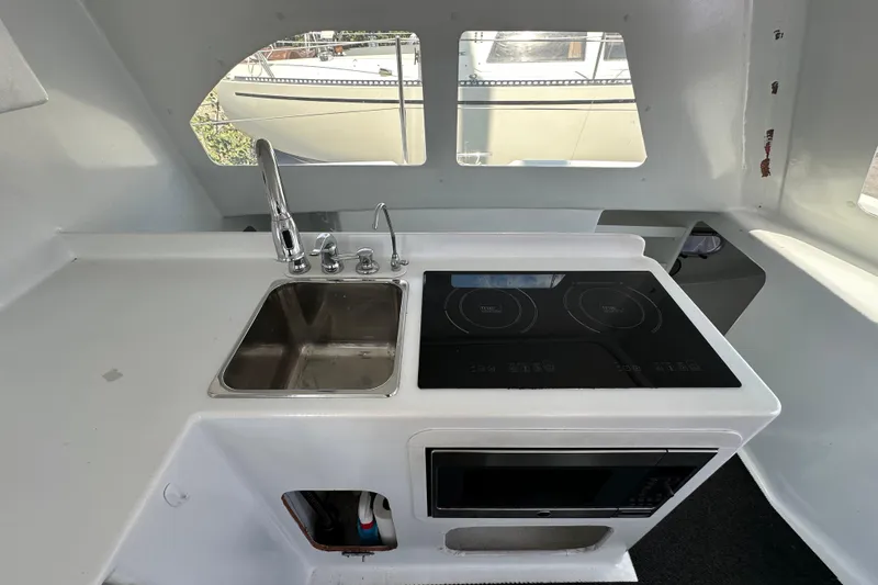Slide: The Image of Compact kitchen area in a 2019 Kelsall 38ma boat with sink, stove, and microwave. - 47