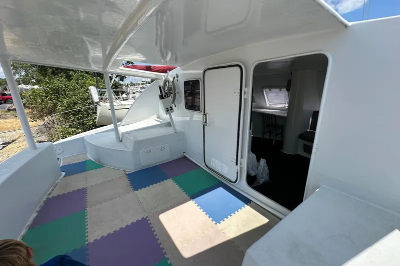 Slide: The Image of 2019 Kelsall 38ma catamaran interior with colorful flooring and open cabin door. - 49