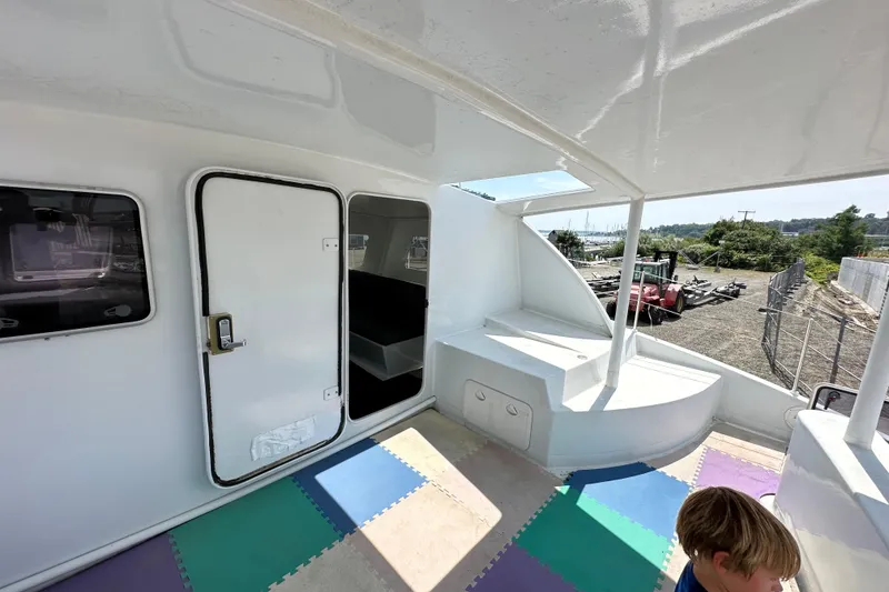 Slide: The Image of Interior view of 2019 Kelsall 38ma boat with colorful floor mats and open door. - 50