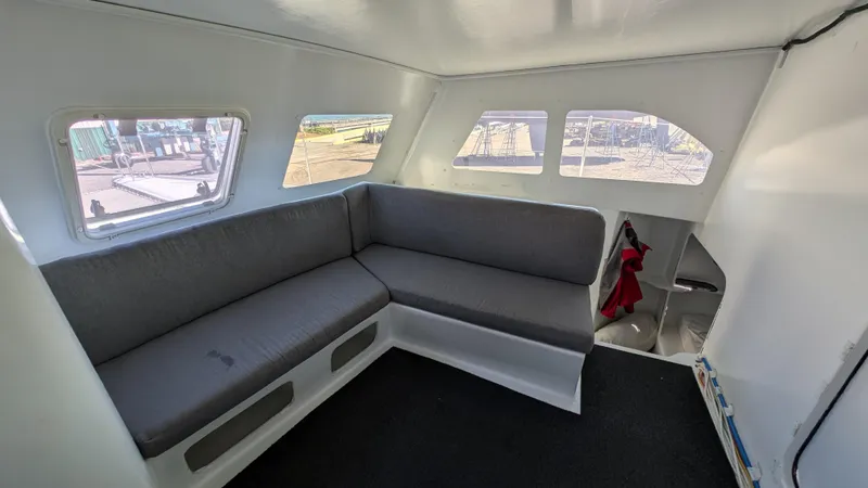 Slide: The Image of Interior of 2019 Kelsall 38ma catamaran with gray seating and large windows. - 6