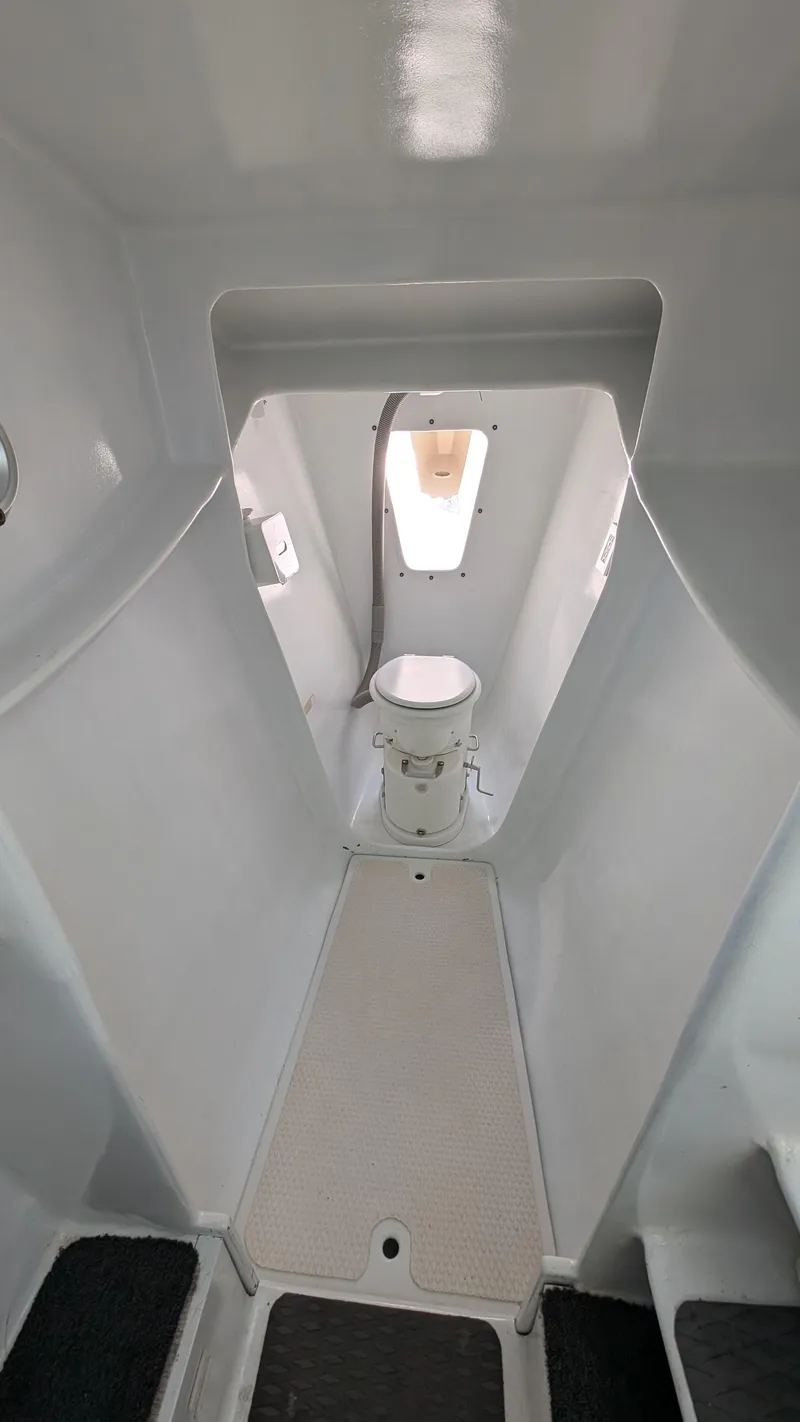 Slide: The Image of Interior of 2019 Kelsall 38ma boat, featuring a compact marine toilet. - 9
