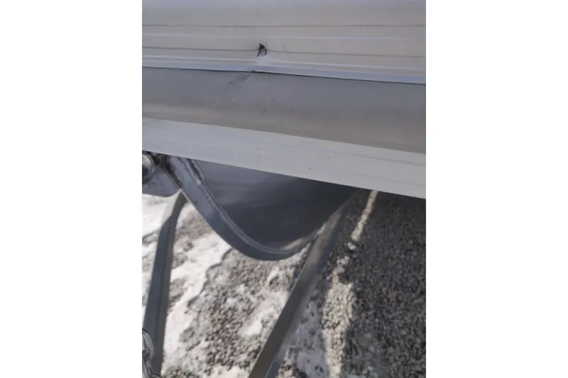 Slide: The Image of 2023 Bennington 21LSB boat with visible exterior damage on the side. - 14