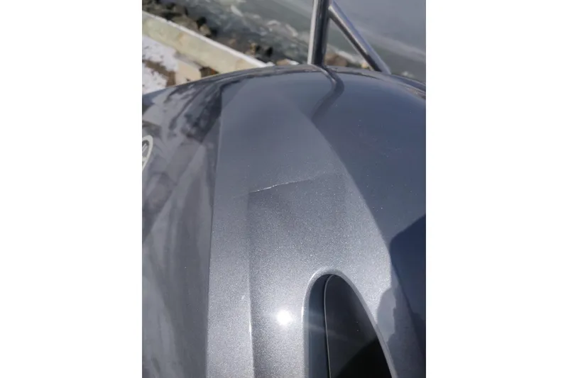 Slide: The Image of Close-up of a 2023 Bennington 21LSB boat's sleek metallic surface by the water. - 16