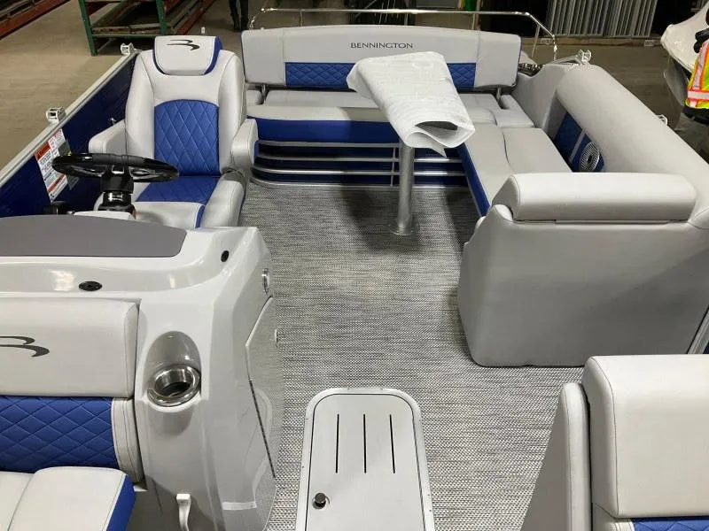 Slide: The Image of 2023 Bennington 21LSB pontoon boat with outboard motor, parked on gravel. - 3