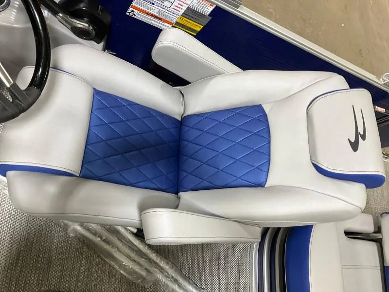 Slide: The Image of 2023 Bennington 21LSB pontoon boat with blue and gray seating, docked at a marina. - 5