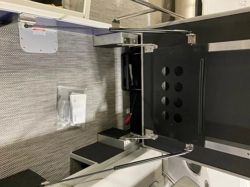 Slide: The Image of 2023 Bennington 21LSB pontoon boat interior with blue and gray seating, docked in snowy area. - 7