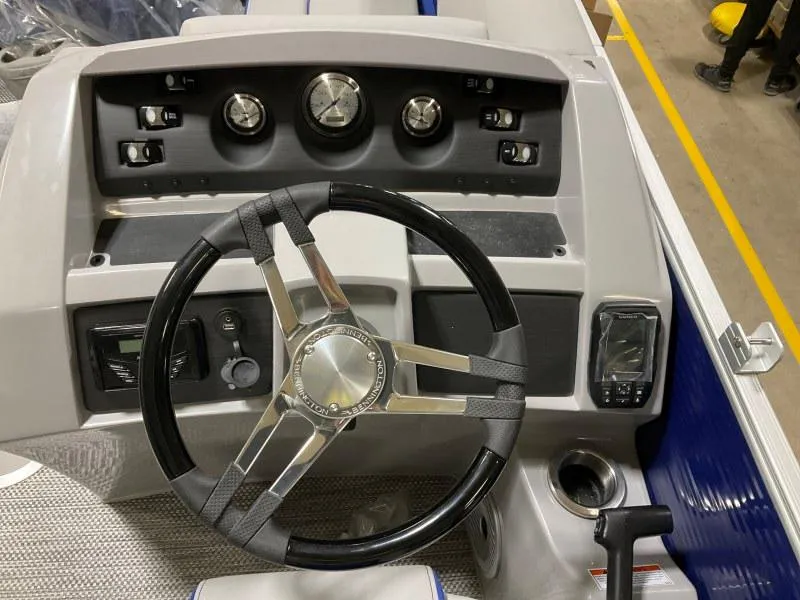 Slide: The Image of 2023 Bennington 21LSB pontoon boat with gray and blue seating at a dock. - 8