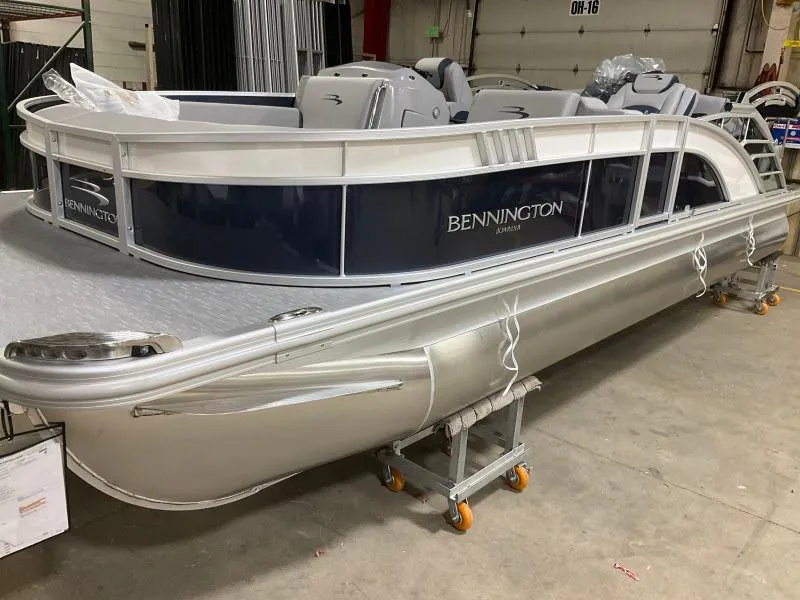 The Image of 2023 Bennington 23LTSB pontoon boat on trailer, parked outdoors under clear sky. - 0