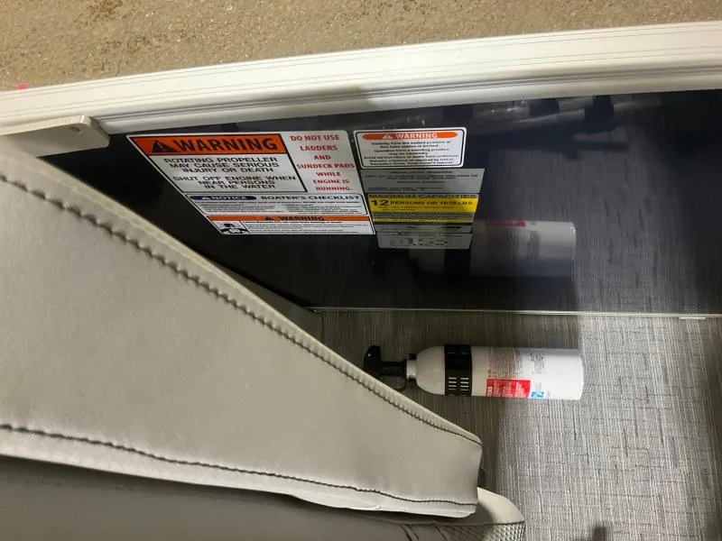 Slide: The Image of 2023 Bennington 23LTSB pontoon boat with blue and gray seating at a marina. - 11