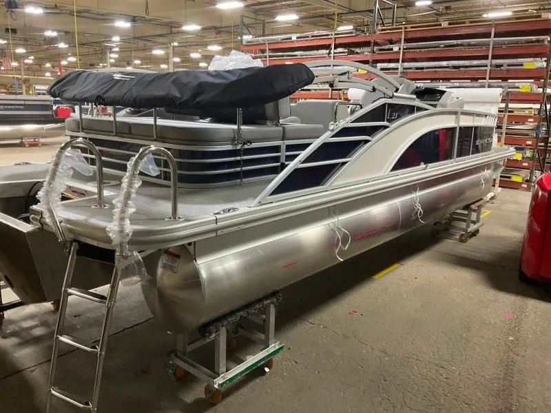 Slide: The Image of 2023 Bennington 23LTSB pontoon boat on trailer, parked on gravel with cloudy sky. - 3