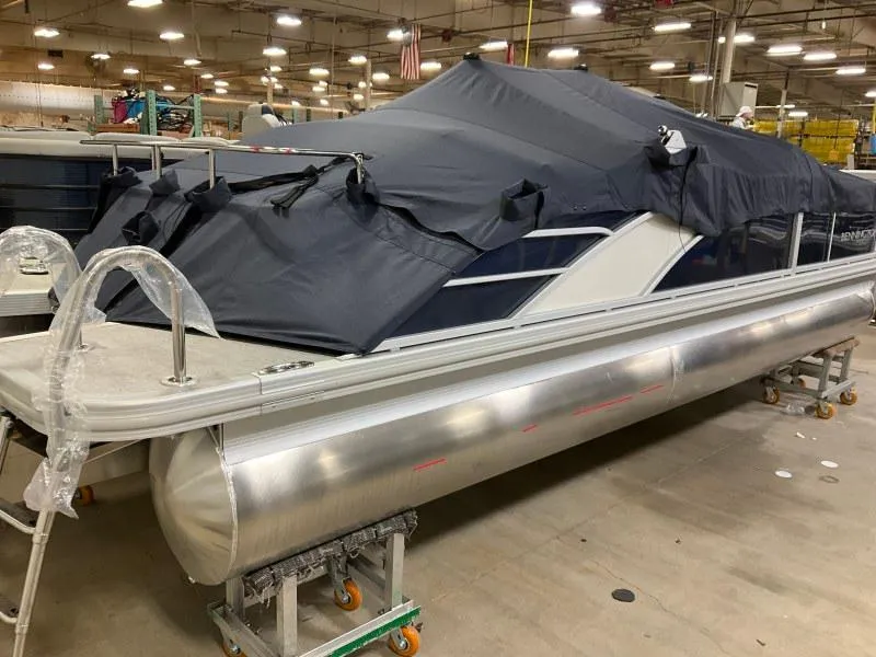 Slide: The Image of 2023 Bennington 23LTSB pontoon boat on trailer, parked near a marina. - 4