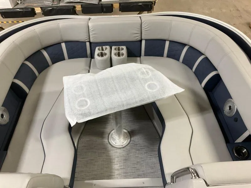 Slide: The Image of 2023 Bennington 23LTSB boat interior with seating and helm, docked under clear sky. - 8