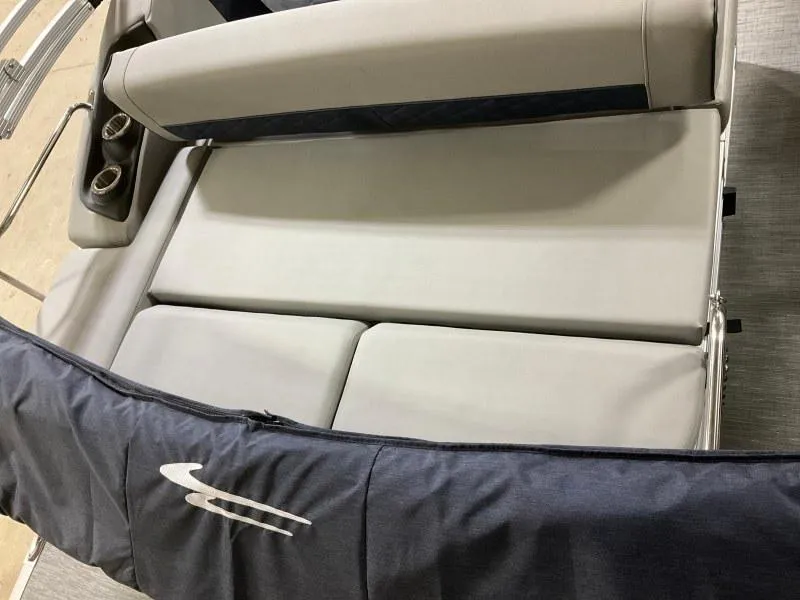 Slide: The Image of 2023 Bennington 23LTSB boat interior with seating and table at a marina. - 9