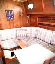 Slide: The Image of Cozy interior of 1990 Pacific Seacraft 37 sailboat with plaid seating and wooden accents. - 2