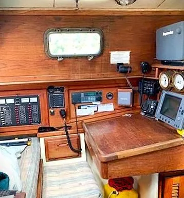 Slide: The Image of 1990 Pacific Seacraft 37 sailboat navigation station with instruments and wooden interior. - 4