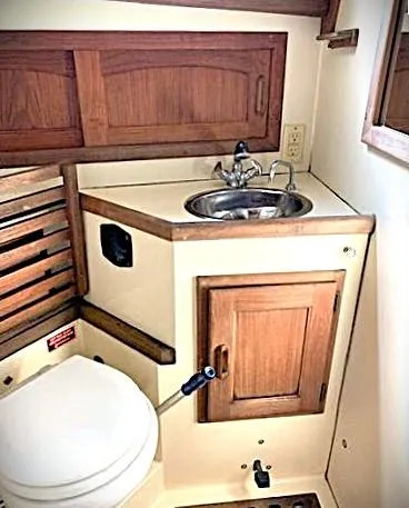 Slide: The Image of 1990 Pacific Seacraft 37 yacht bathroom with wooden cabinetry and compact sink. - 5