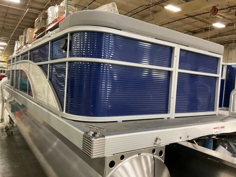 Slide: The Image of 2023 Bennington 208SL pontoon boat on trailer under cloudy sky. - 2