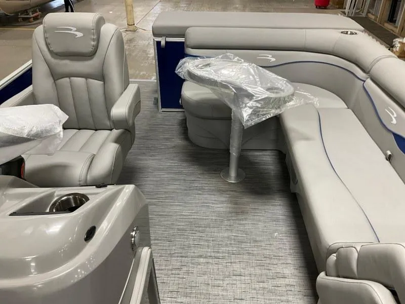 Slide: The Image of 2023 Bennington 208SL pontoon boat with gray seating, docked by a serene waterfront. - 8