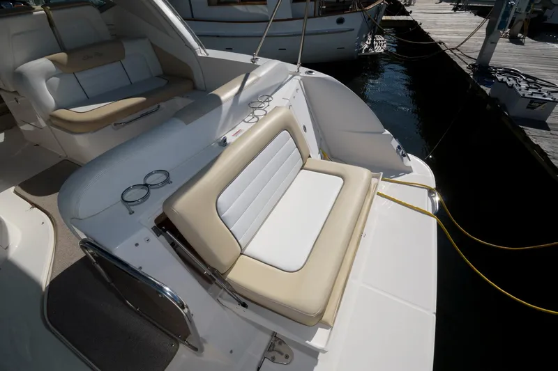 Slide: The Image of 2009 Sea Ray 330 Sundancer boat interior with cushioned seating and dock view. - 13