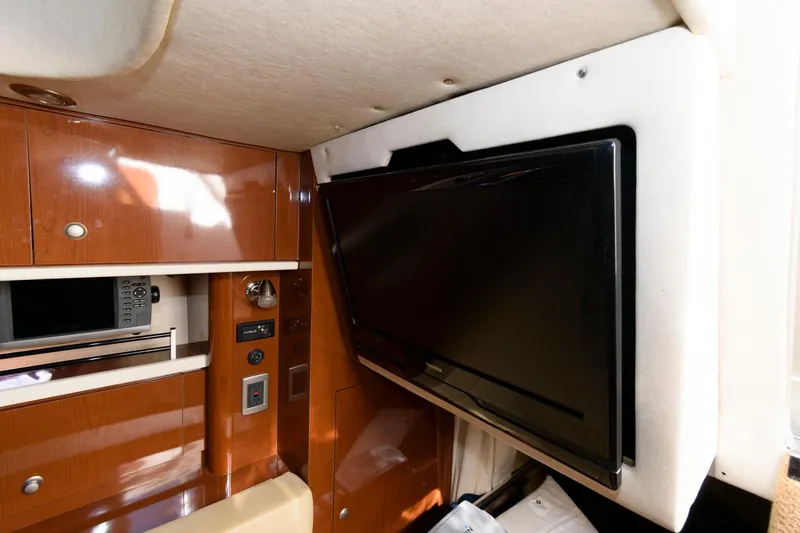 Slide: The Image of Interior of 2009 Sea Ray 330 Sundancer with mounted TV and wooden cabinetry. - 18