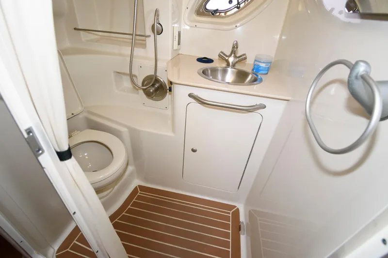 Slide: The Image of 2009 Sea Ray 330 Sundancer bathroom with toilet, sink, and shower in compact marine design. - 19