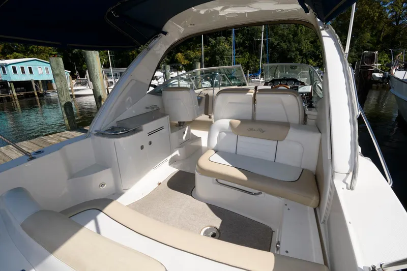 Slide: The Image of 2009 Sea Ray 330 Sundancer interior with beige seating, docked at a marina. - 4