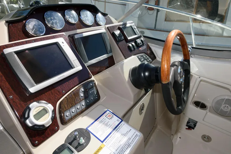 Slide: The Image of 2009 Sea Ray 330 Sundancer helm with wood steering wheel and modern navigation instruments. - 7
