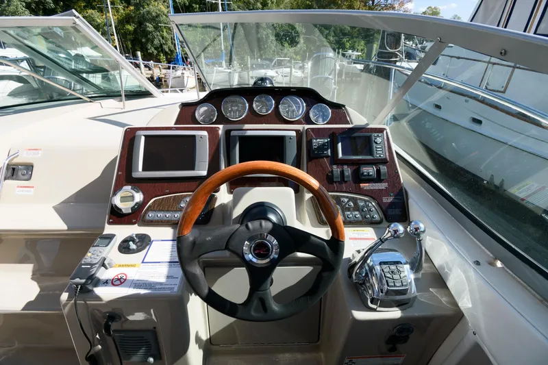 Slide: The Image of 2009 Sea Ray 330 Sundancer helm with wood steering wheel and modern navigation instruments. - 8