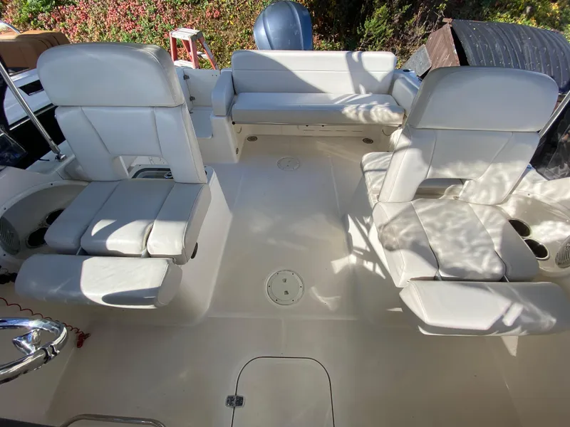 Slide: The Image of 2013 Pursuit DC 235 Dual Console boat interior with white seating and spacious layout. - 3