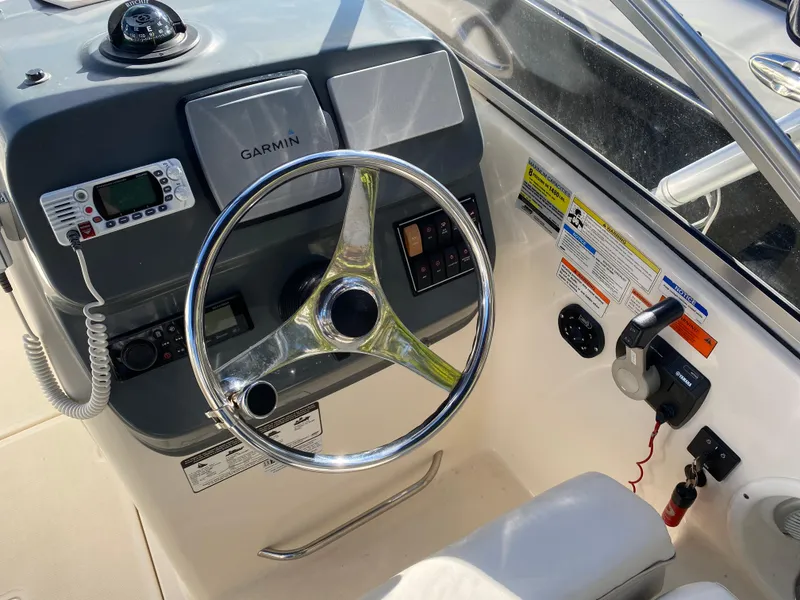 Slide: The Image of 2013 Pursuit DC 235 Dual Console boat dashboard with Garmin navigation system and steering wheel. - 5