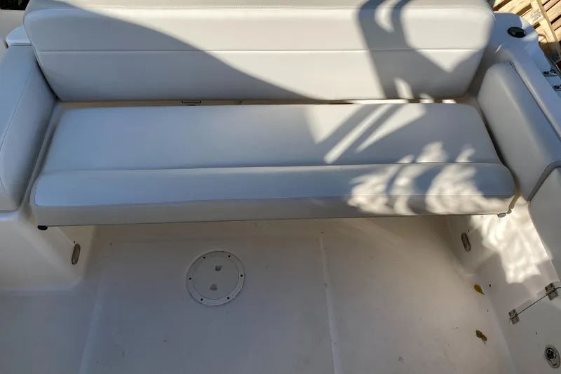 Slide: The Image of 2013 Pursuit DC 235 Dual Console boat interior with white cushioned seating. - 7